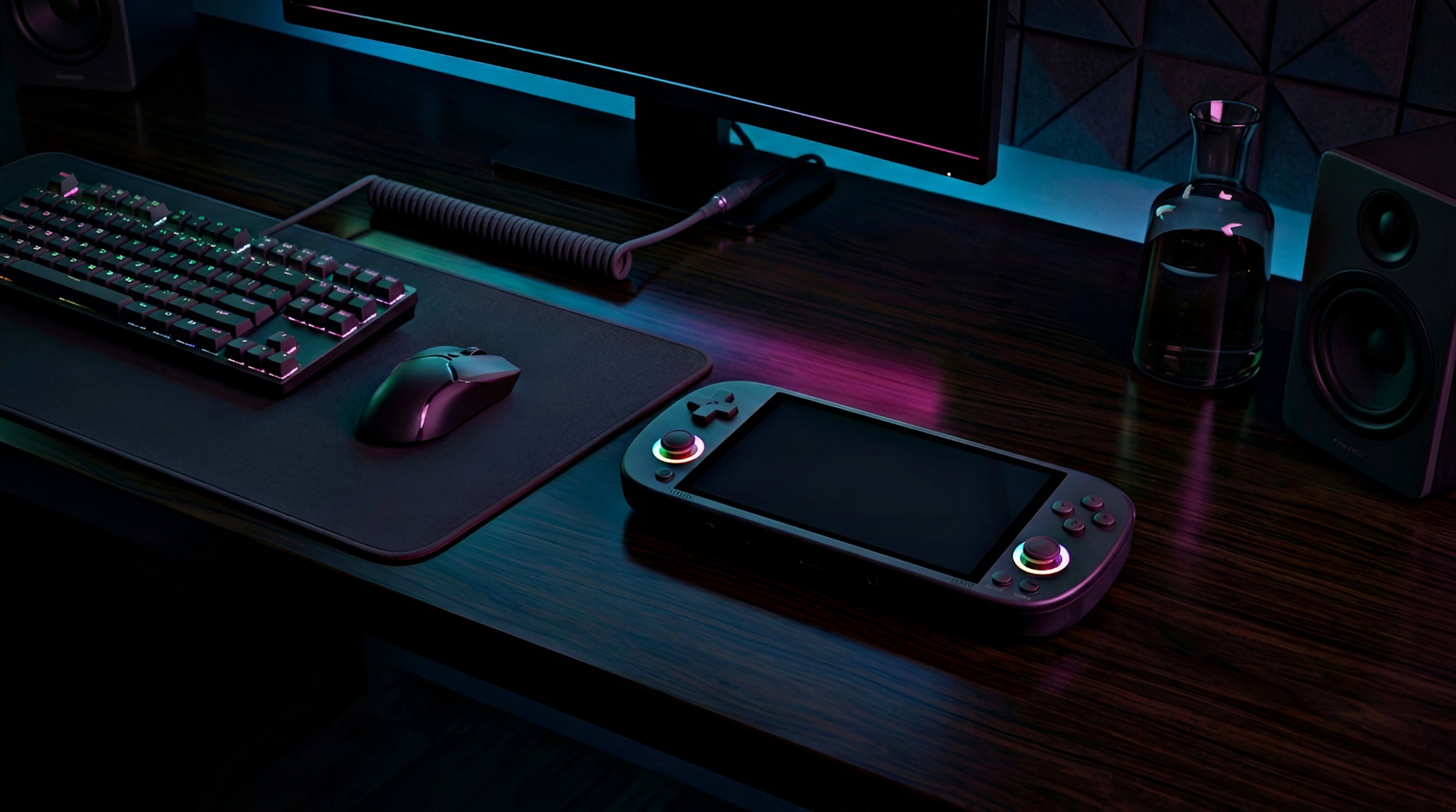 Gaming setup with handheld console, keyboard, and mouse on a dark desk.