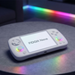 FIDGIX Nova handheld device on a dark surface with rainbow lighting